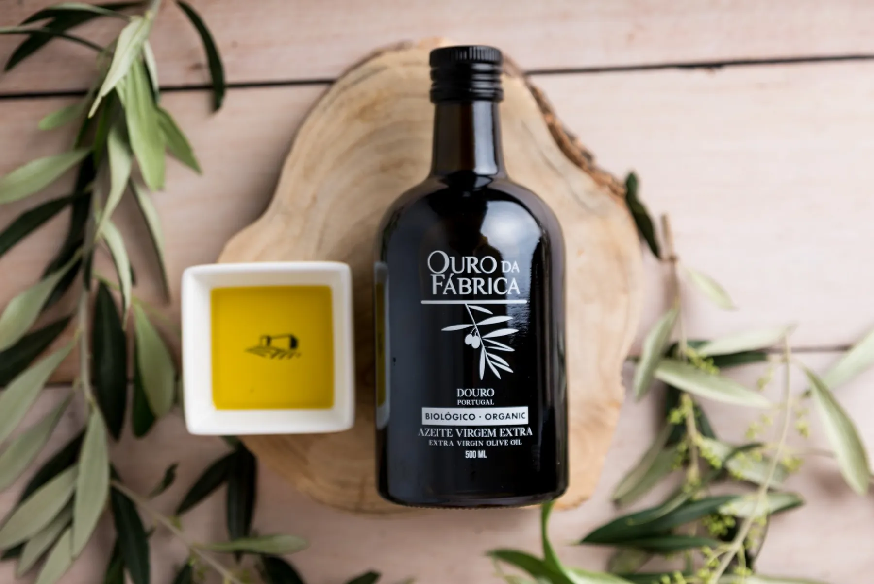 Garrafa Ouro da Fábrica com uma taça de azeite e ramos de oliveira